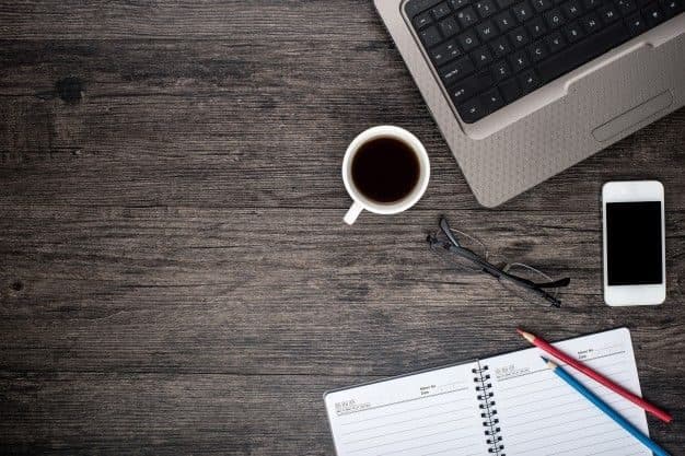 Desk with a laptop, a cup of coffee and a calendar Free Photo